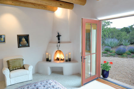 The living room fireplace and banco, both made from adobe and natural gypsum plaster, get plenty of use during the holidays when family and friends gather.